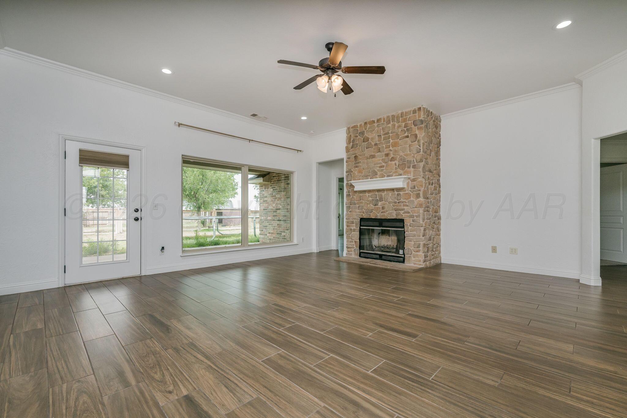 16700 Dove Meadow Road Canyon, TX 79015 - Photo 3 of 24 a view of an empty room with wooden floor fireplace and a window
