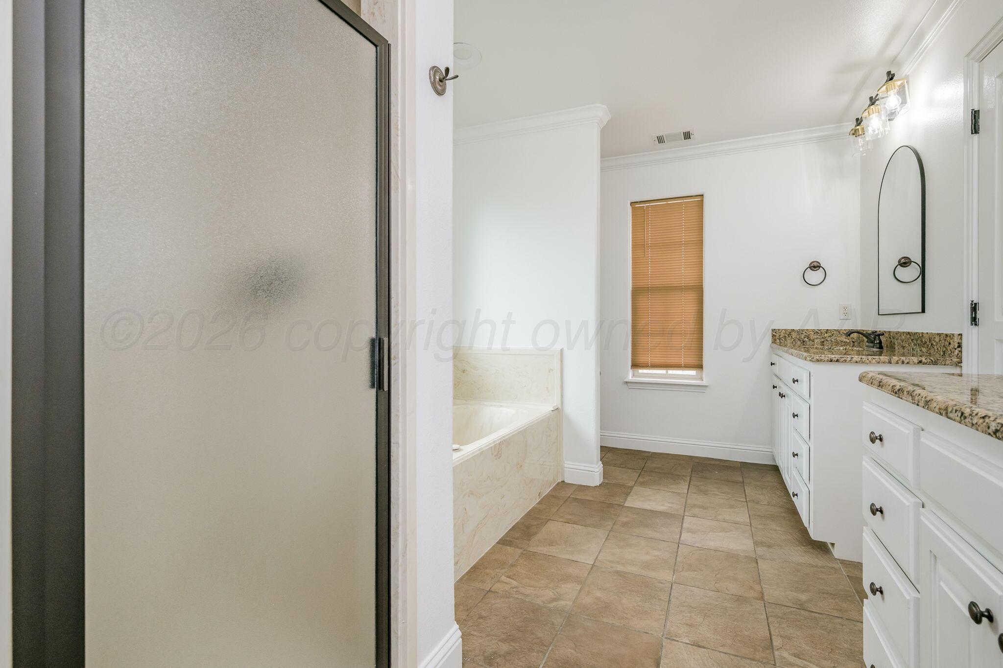 16700 Dove Meadow Road Canyon, TX 79015 - Photo 10 of 24 a spacious bathroom with a granite countertop sink a mirror and a bathtub