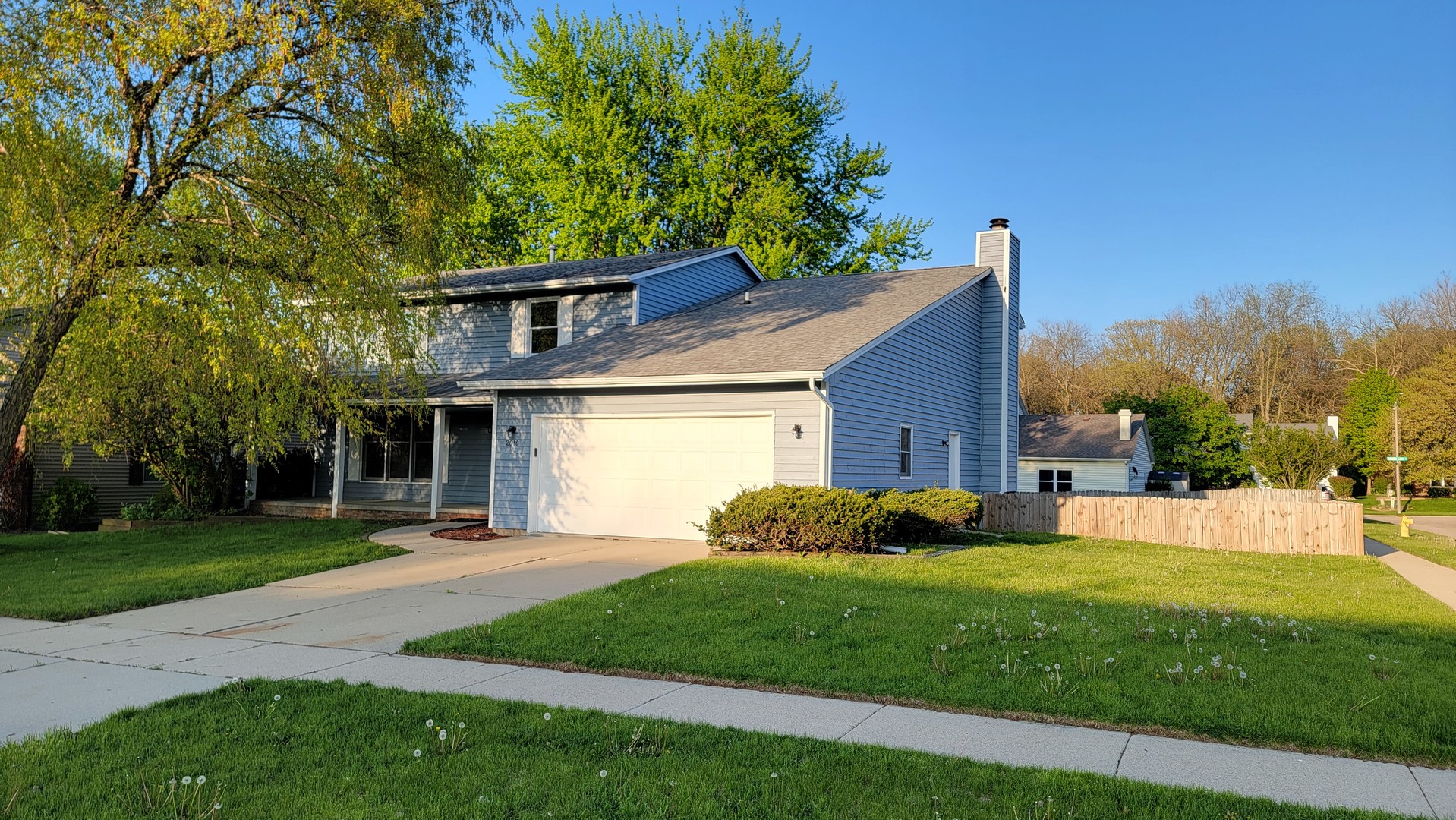 a front view of a house with a yard and trees