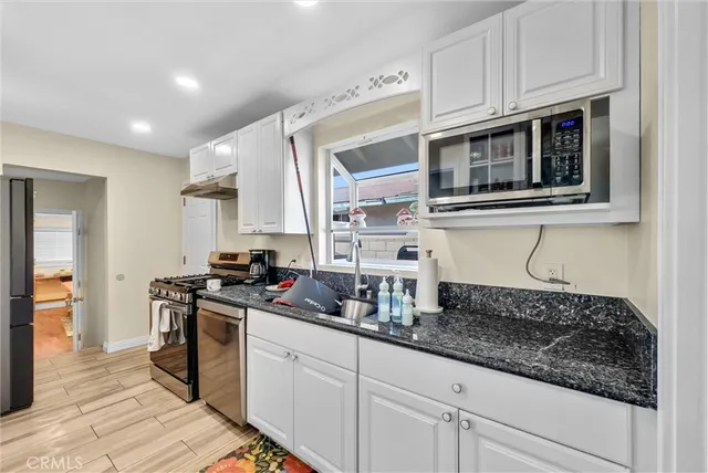 a kitchen with stainless steel appliances granite countertop a sink and a stove