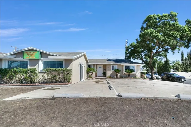 a front view of a house with a yard and potted plants
