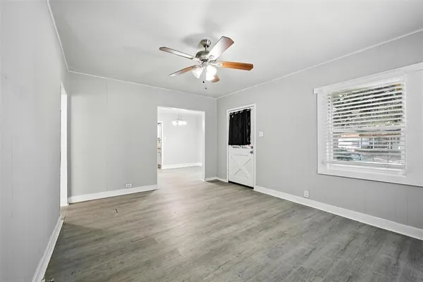 a view of an empty room with a window and wooden floor