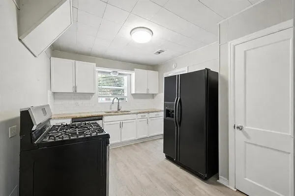 a kitchen with a refrigerator and a stove top oven