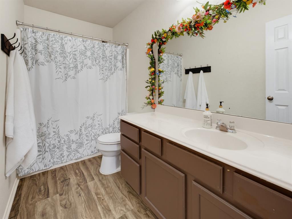 13268 Fencerow Road Fort Worth, TX 76244 - Photo 19 of 25 Bathroom featuring a wood-finish floor and a white shower curtain with a gray leaf pattern