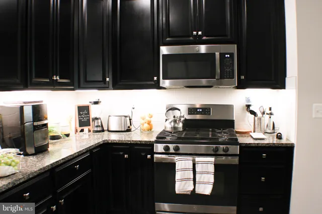 a kitchen with granite countertop a sink and a stove top oven