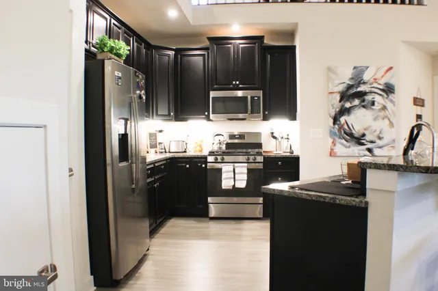 a kitchen with stainless steel appliances granite countertop a refrigerator and a stove