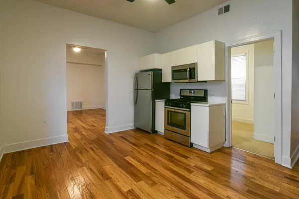 a kitchen with granite countertop a refrigerator and a stove top oven