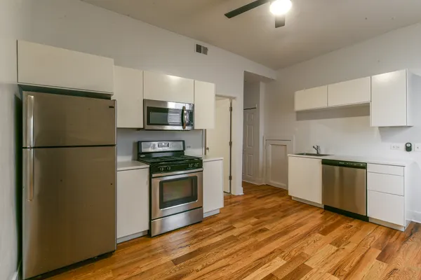 a kitchen with granite countertop a refrigerator stove and sink