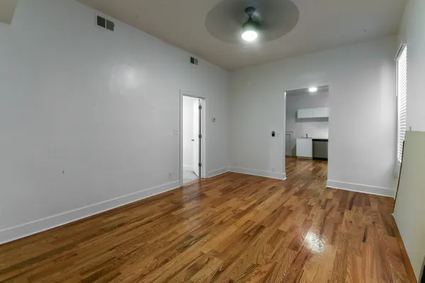 a view of empty room with wooden floor