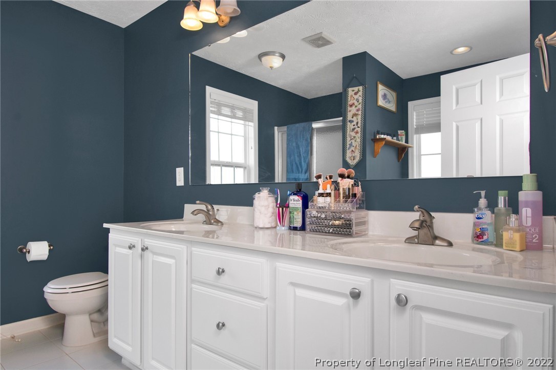 5415 Spreading Branch Road Hope Mills, NC 28348 - Photo 10 of 12 a bathroom with a toilet sink and mirror