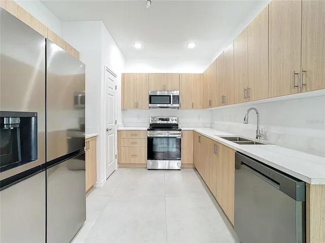 a kitchen with stainless steel appliances a refrigerator and a sink