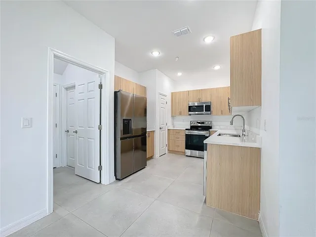 a kitchen with stainless steel appliances granite countertop a sink stove and refrigerator