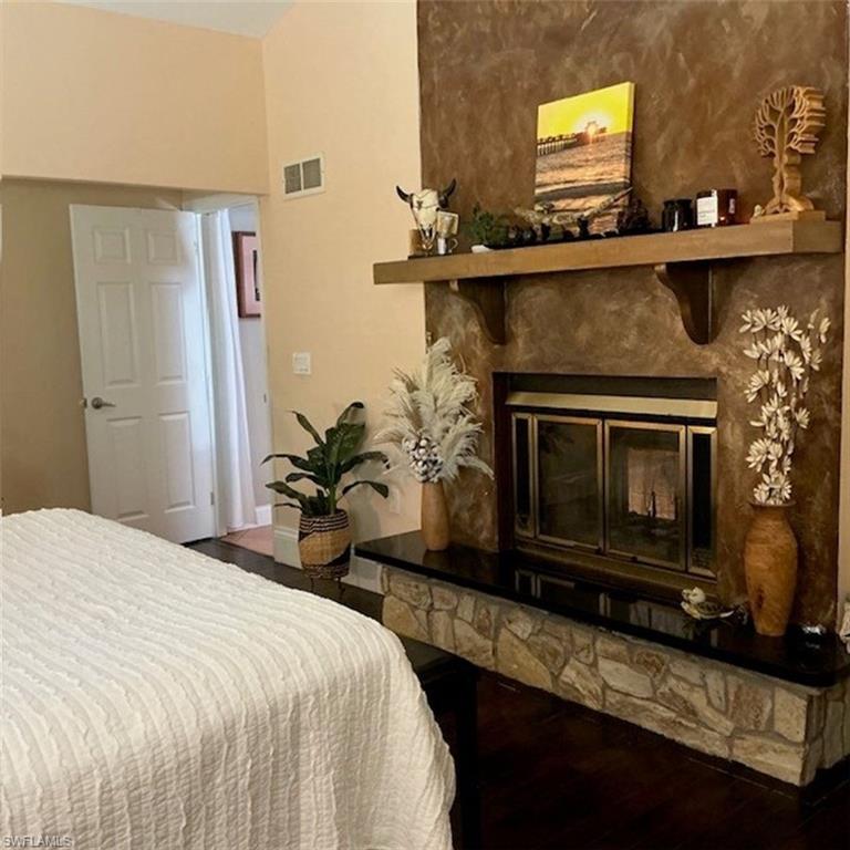 882 Bluebird Street Naples, FL 34104 - Photo 4 of 10 a bedroom with a bed and a fireplace