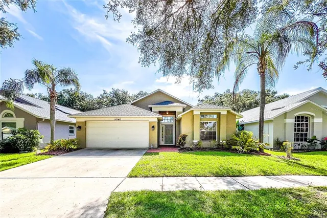 a front view of a house with a yard and palm trees