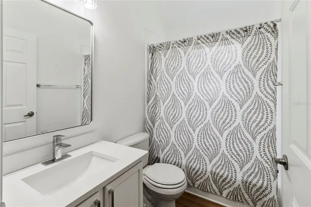 a bathroom with a sink toilet and a mirror