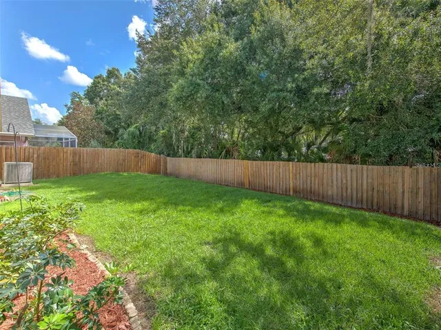a view of backyard with wooden fence