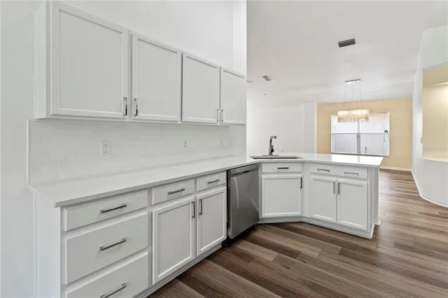 a kitchen with white cabinets and sink