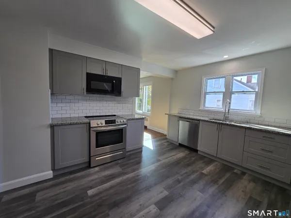 a kitchen with a stove and a wooden floor