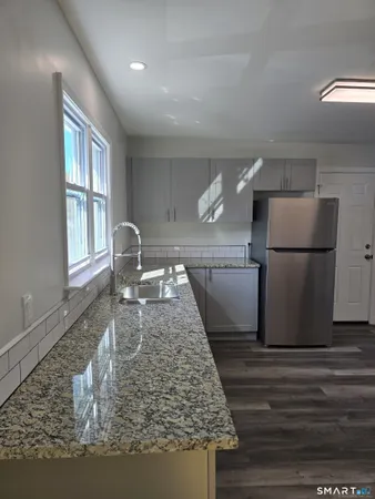 a kitchen with a refrigerator and wooden cabinets