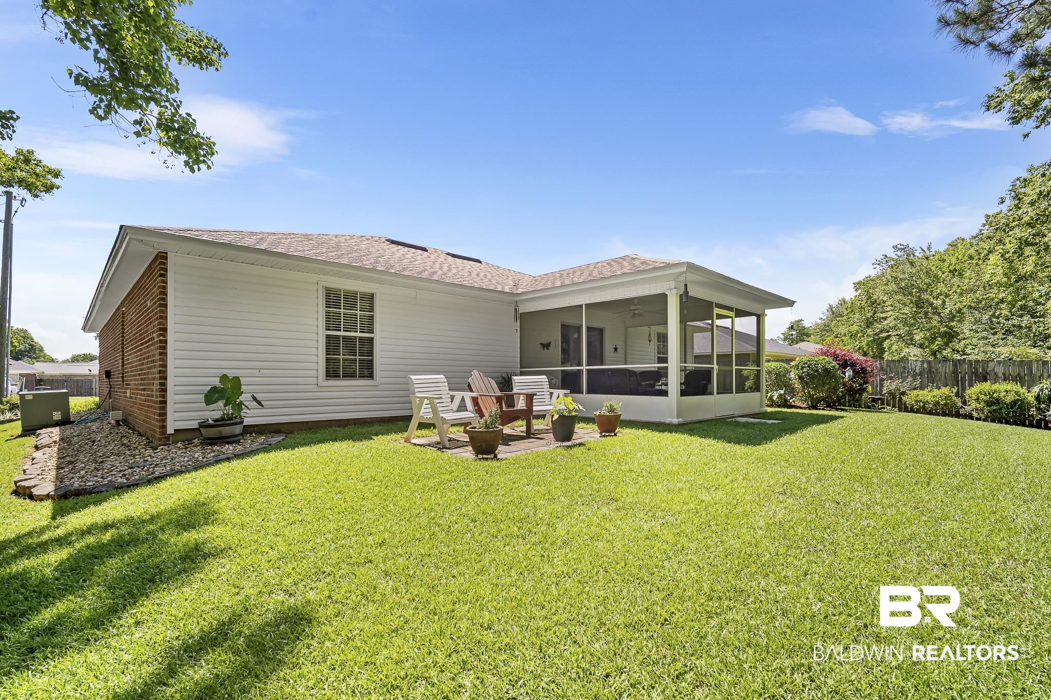 1802 South Bay Street Foley, AL 36535 - Photo 26 of 30 Rear view of property with a sunroom, a ceiling fan, and a shingled roof