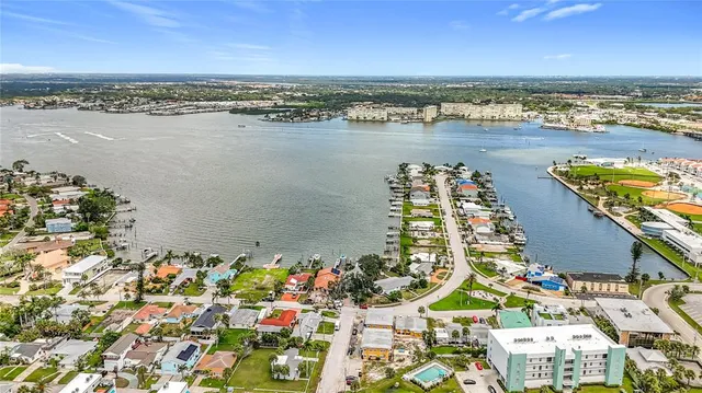 an aerial view of ocean and residential houses with outdoor space