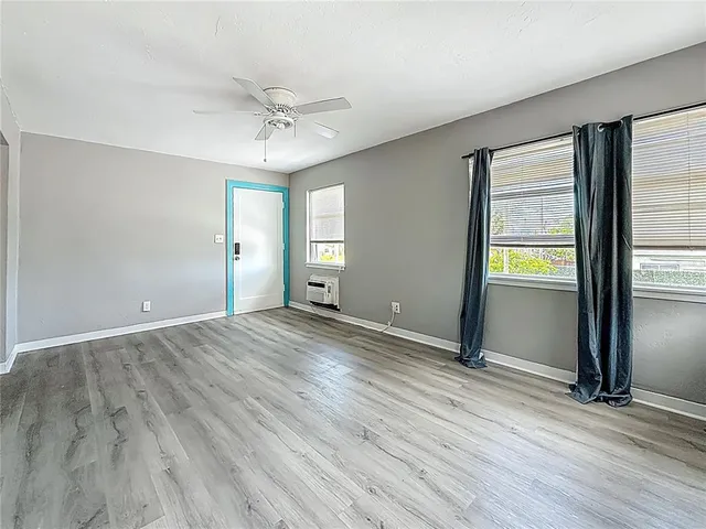 an empty room with wooden floor and door