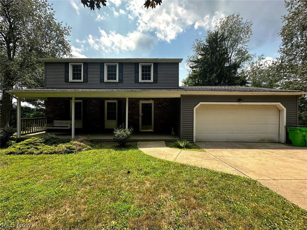 2093 Cambridge Road Coshocton, OH 43812 - Photo 1 of 32 View of front of home with a porch, a garage, and a front lawn