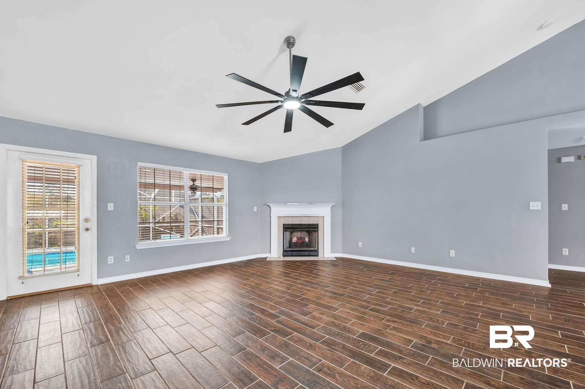 16444 Hamlet Lane Foley, AL 36535 - Photo 16 of 49 Unfurnished living room featuring baseboards, a fireplace, a ceiling fan, dark wood finished floors, and vaulted ceiling