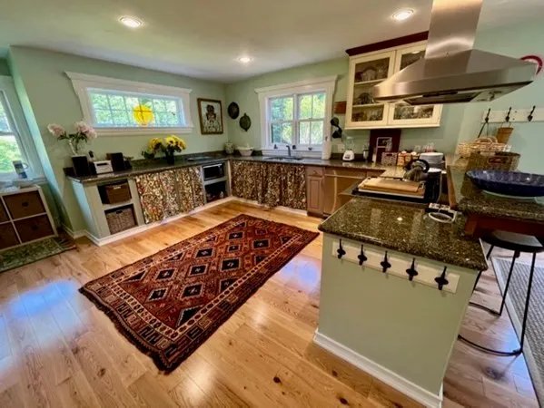 a kitchen with stainless steel appliances granite countertop a stove a sink and a microwave