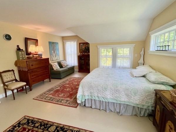 165 Christiantown Road West Tisbury, MA 02568 - Photo 6 of 8 a spacious bedroom with a bed a table and chair