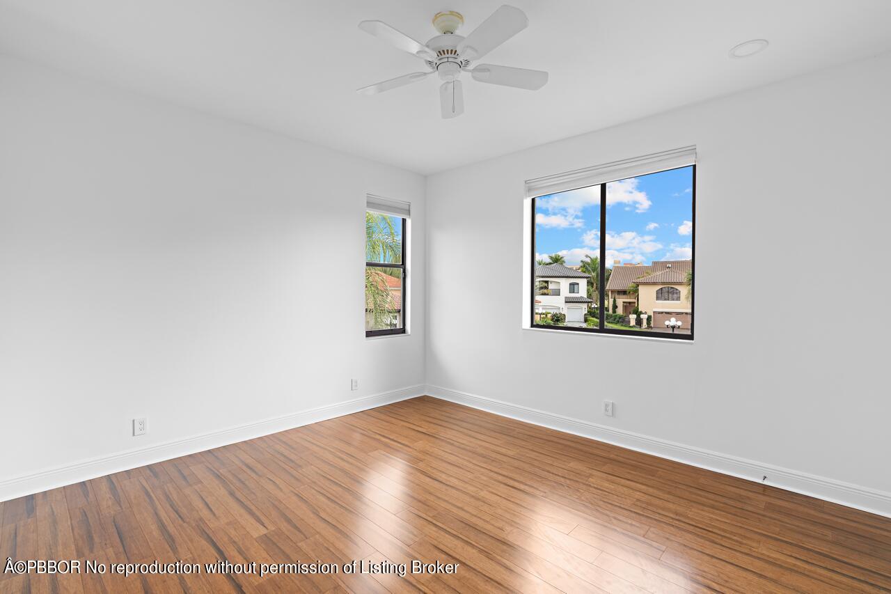 22771 El Dorado Drive Boca Raton, FL 33433 - Photo 16 of 24 an empty room with wooden floor ceiling fan and windows