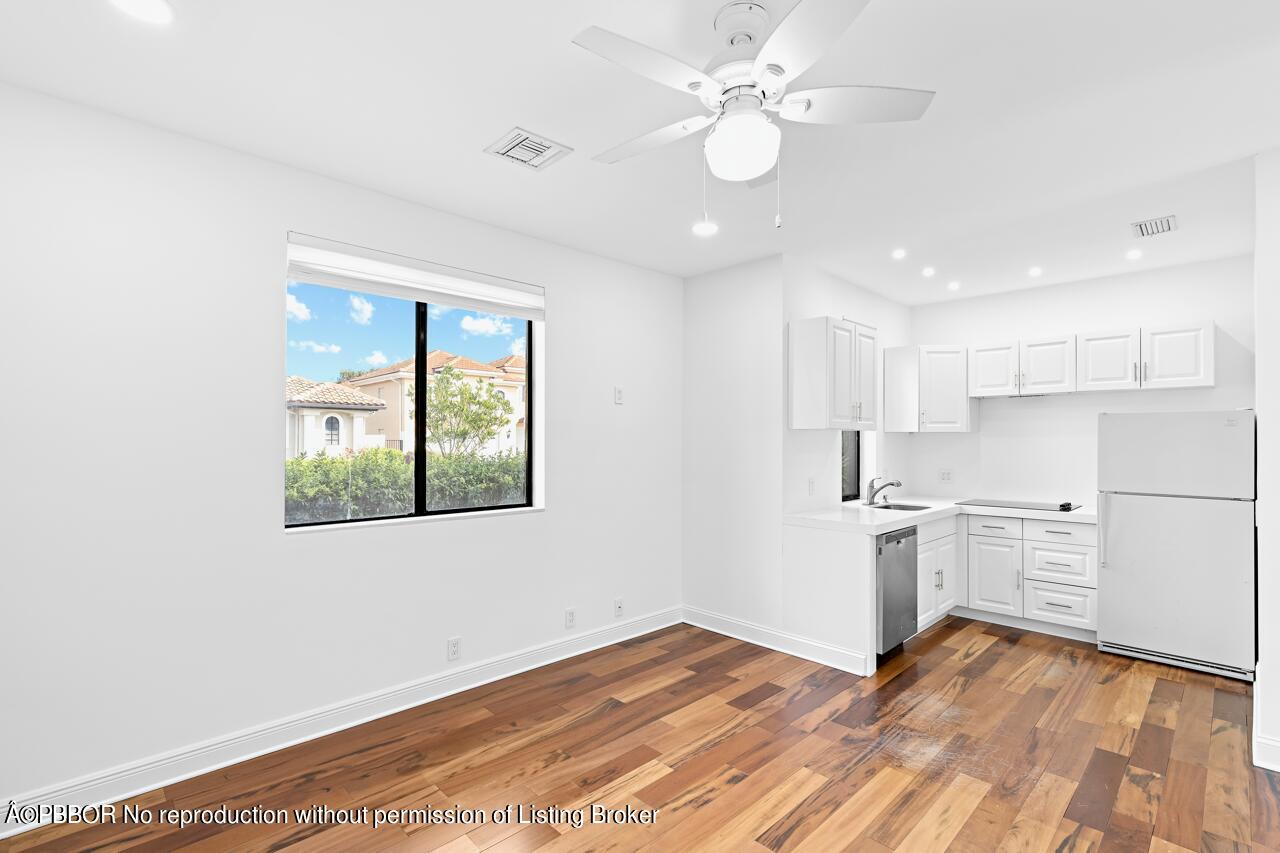 22771 El Dorado Drive Boca Raton, FL 33433 - Photo 18 of 24 a view of a kitchen with a stove cabinets a ceiling fan and wooden floor