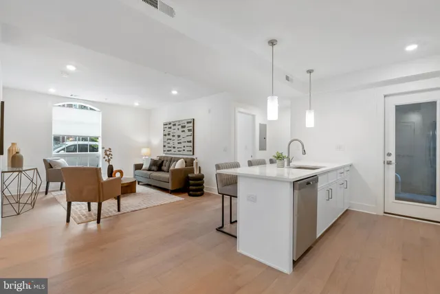 a large white kitchen with a large window and couch