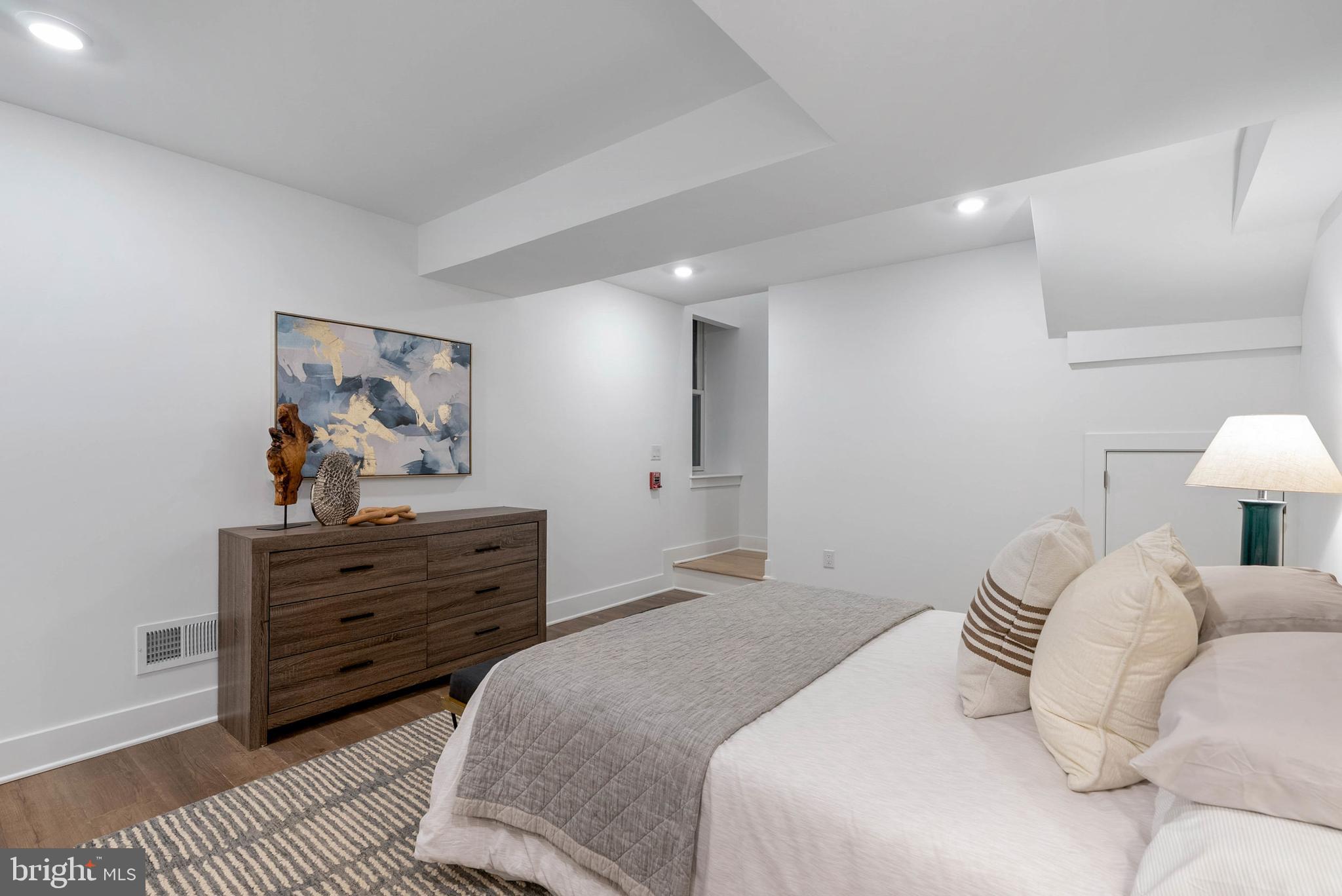 825 Bainbridge Street, Unit 101 Philadelphia, PA 19147 - Photo 18 of 27 a bedroom with a bed and a lamp on dresser