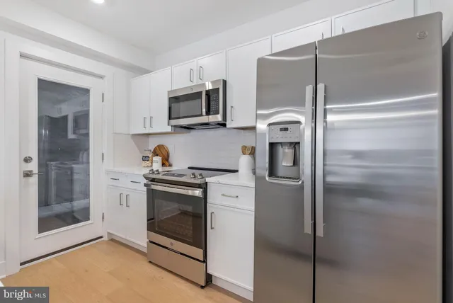 a kitchen with white cabinets and stainless steel appliances