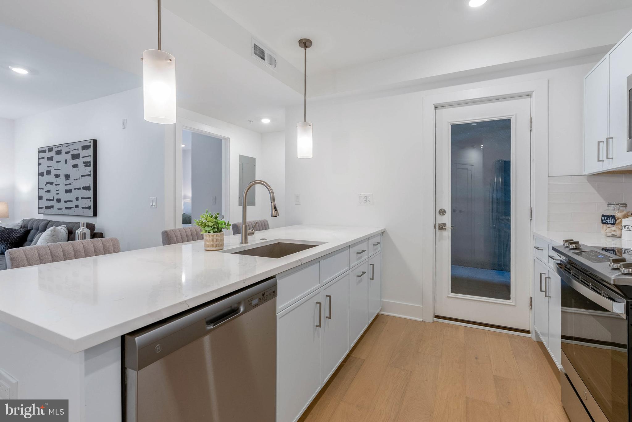 825 Bainbridge Street, Unit 101 Philadelphia, PA 19147 - Photo 4 of 27 a kitchen with a sink a counter space and cabinets