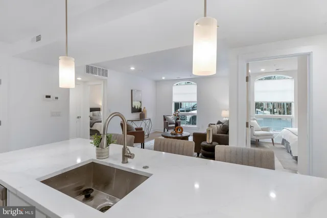 a kitchen island with a sink cabinets and living room view