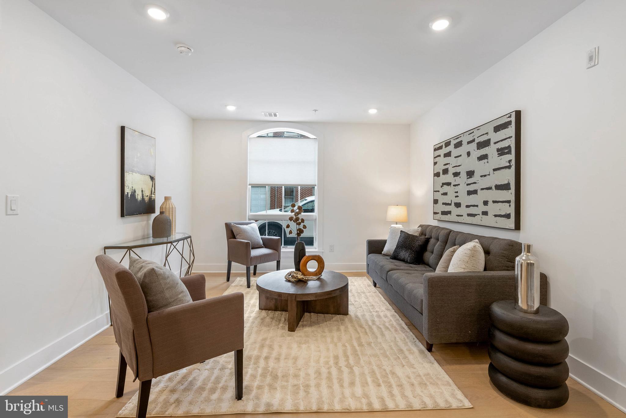 825 Bainbridge Street, Unit 101 Philadelphia, PA 19147 - Photo 8 of 27 a living room with furniture a rug and a lamp