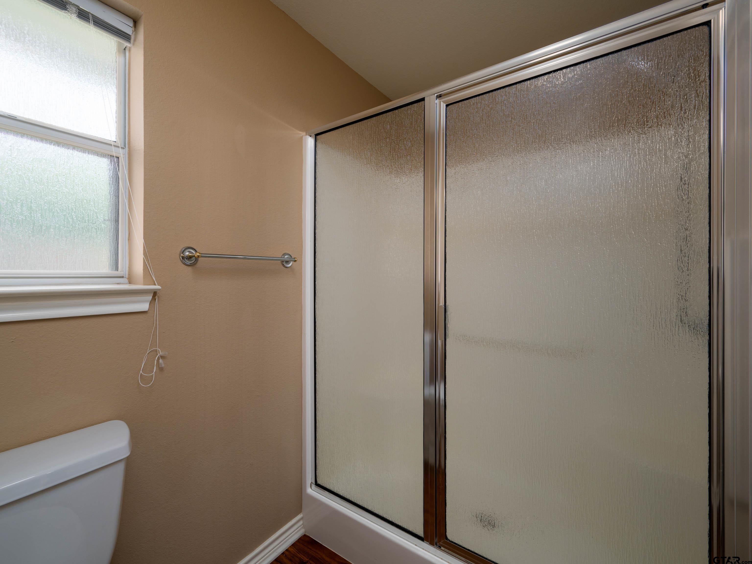 1521 Rice Road Tyler, TX 75703 - Photo 15 of 23 a bathroom with a glass shower door