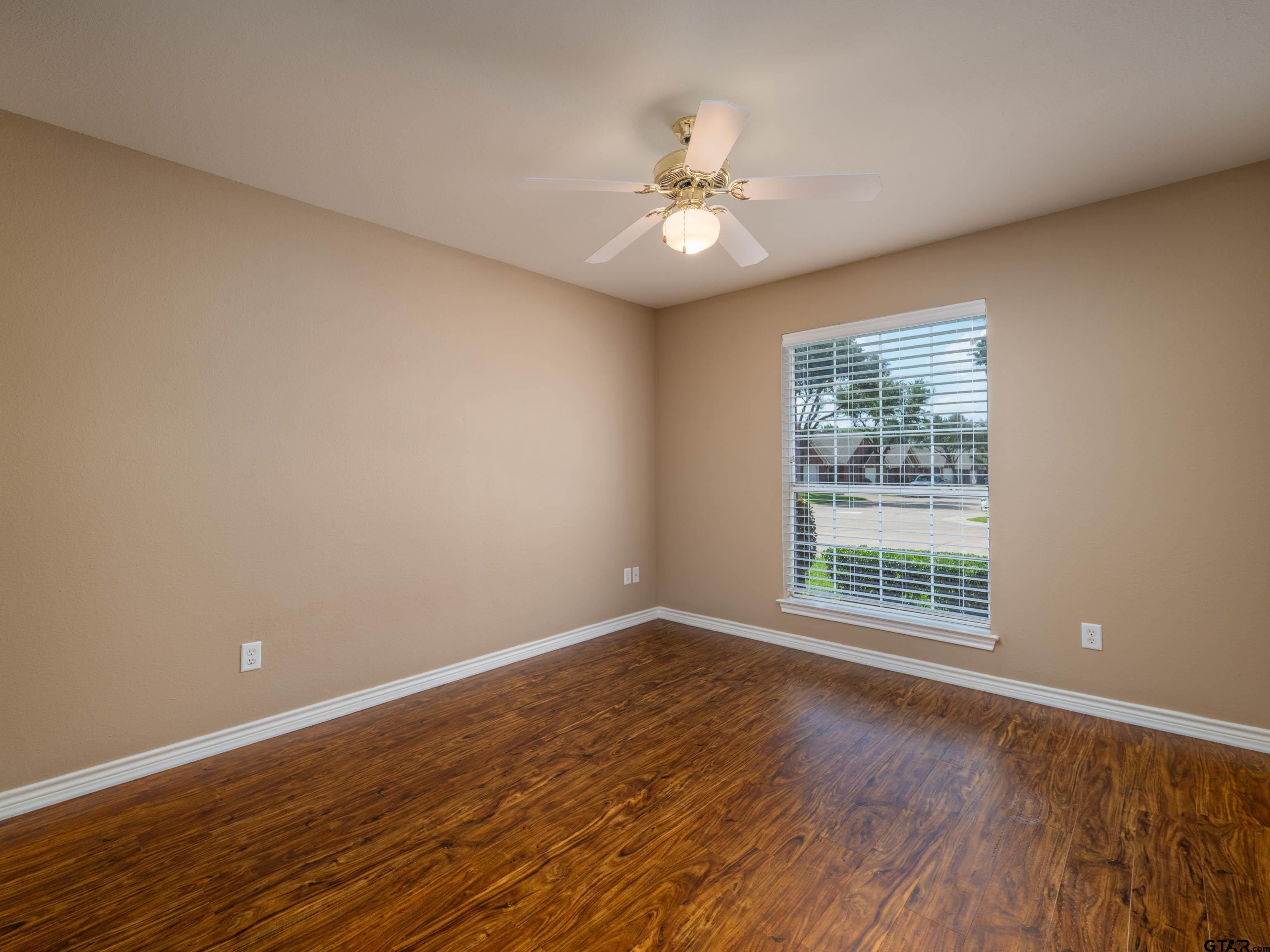 1521 Rice Road Tyler, TX 75703 - Photo 16 of 23 a view of an empty room with wooden floor and a window