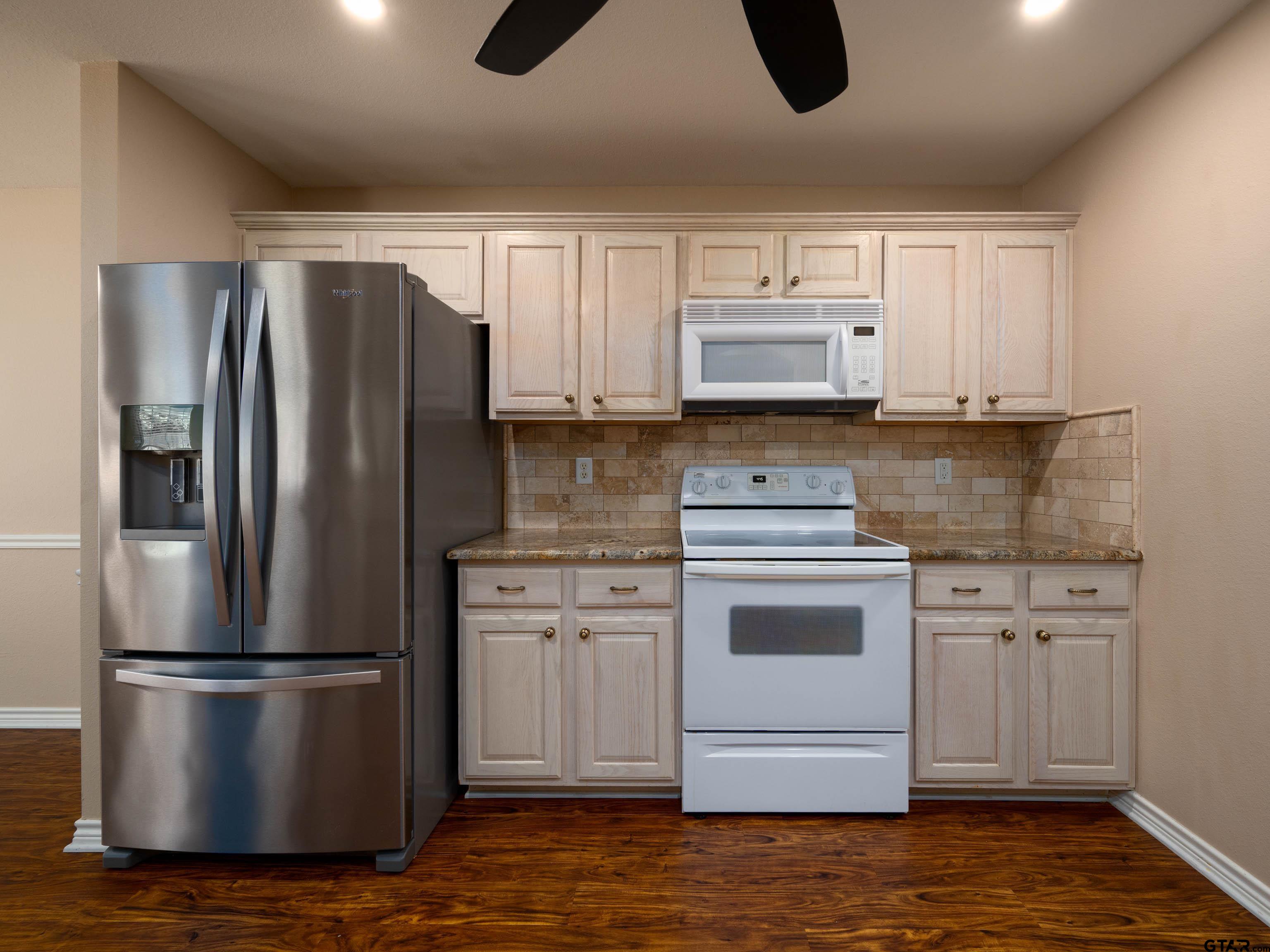1521 Rice Road Tyler, TX 75703 - Photo 8 of 23 a kitchen with a refrigerator sink and cabinets