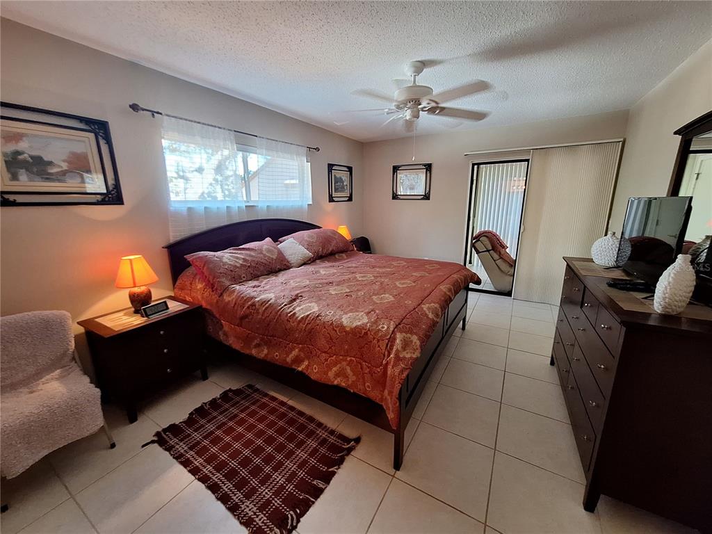 1697 Brookhouse Circle, Unit 217 Sarasota, FL 34231 - Photo 11 of 24 a bedroom with a bed lamp and dresser