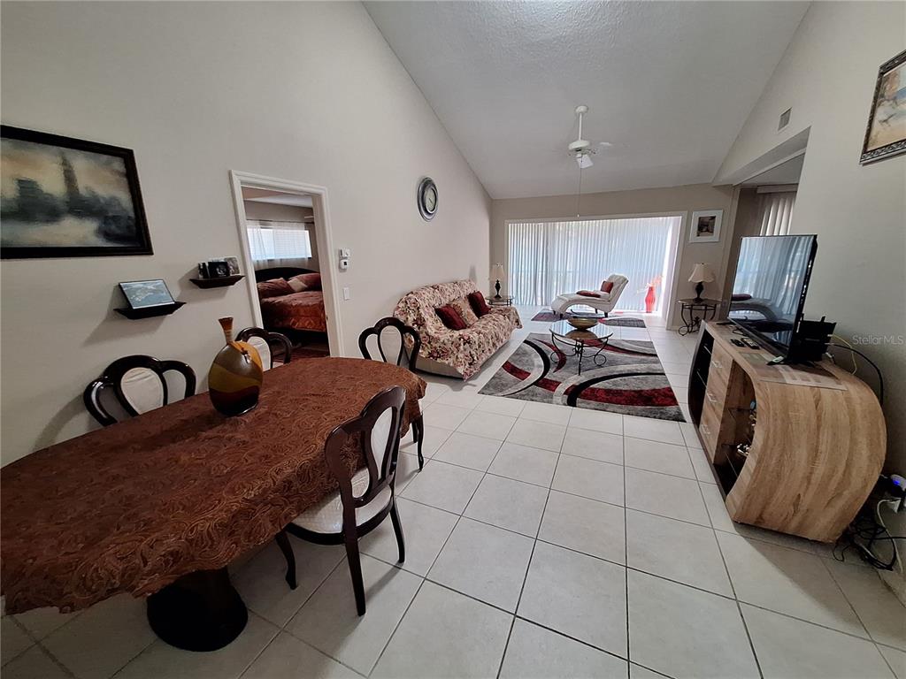 1697 Brookhouse Circle, Unit 217 Sarasota, FL 34231 - Photo 3 of 24 a living room with furniture a flat screen tv and gym equipment