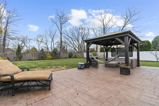 a view of a patio with table and chairs under an umbrella