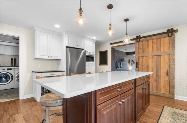 a kitchen with kitchen island a counter top space a sink a refrigerator and cabinets