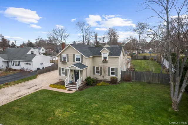 a white house with a big yard and large trees