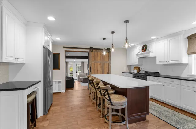 a kitchen with kitchen island a dining table chairs cabinets and stainless steel appliances