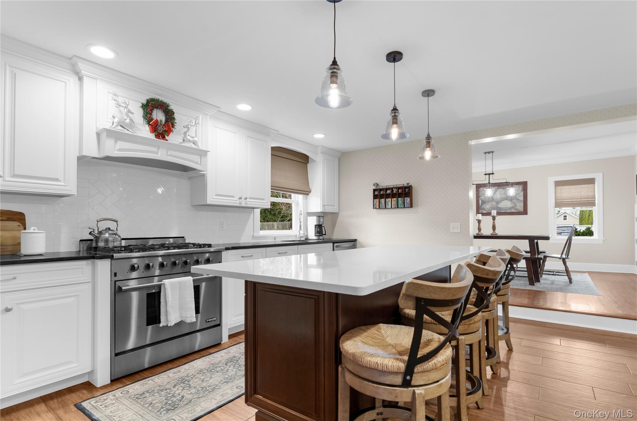 117 Union Avenue Islip, NY 11751 - Photo 10 of 33 a kitchen with stainless steel appliances granite countertop a stove a sink a dining table and chairs with wooden floor