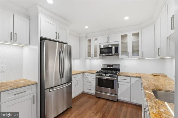 a kitchen with stainless steel appliances granite countertop a refrigerator stove and sink
