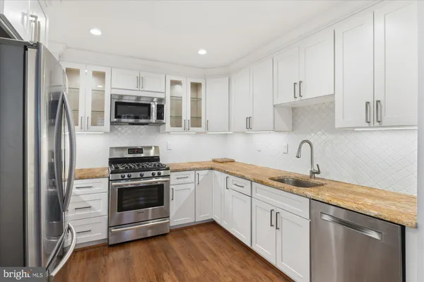 a kitchen with white cabinets and stainless steel appliances